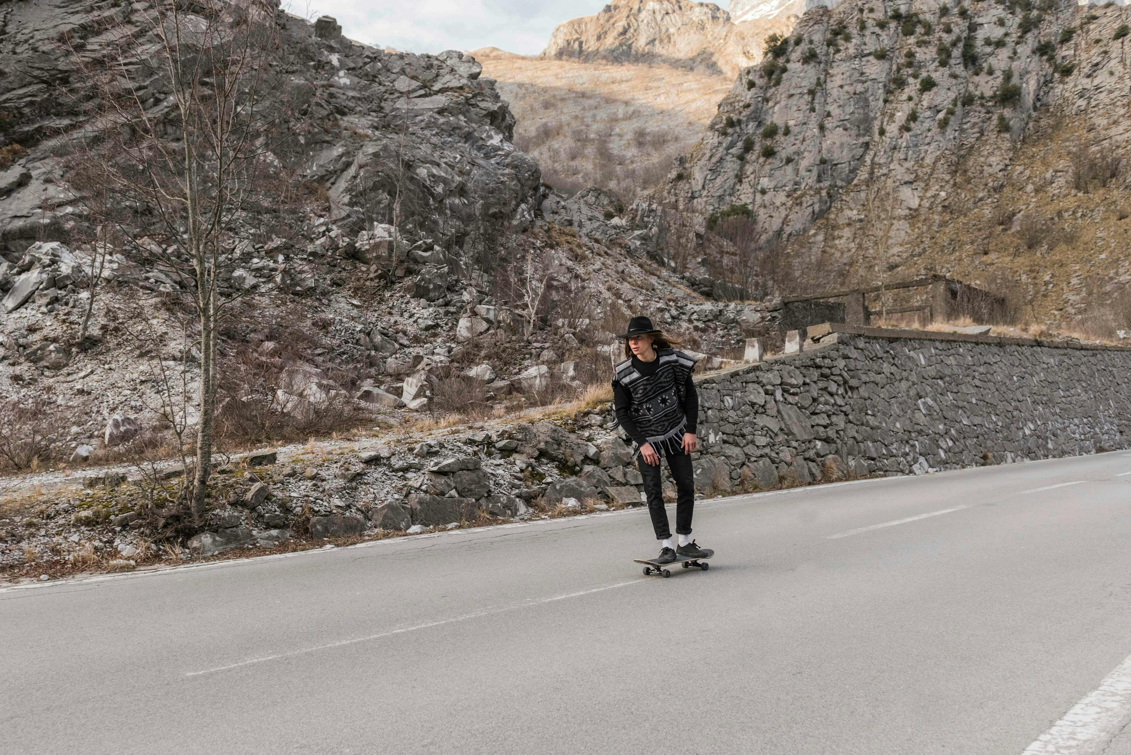 person human road asphalt tarmac clothing apparel sport skateboard nature