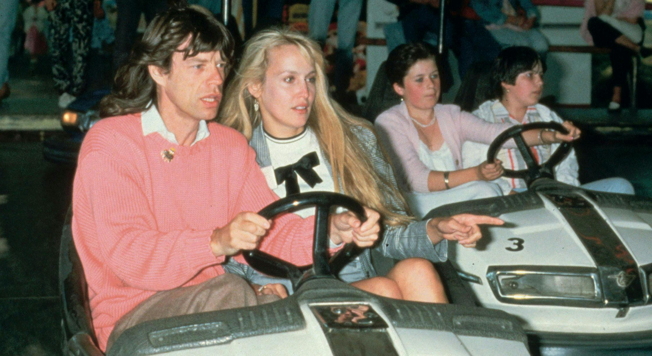 men bumper cars english group of people women recreation girl music mick jagger jerry hall festival american rock music couples caucasian ethnicity prominent persons rolling stones child driving boy person human transportation kart vehicle