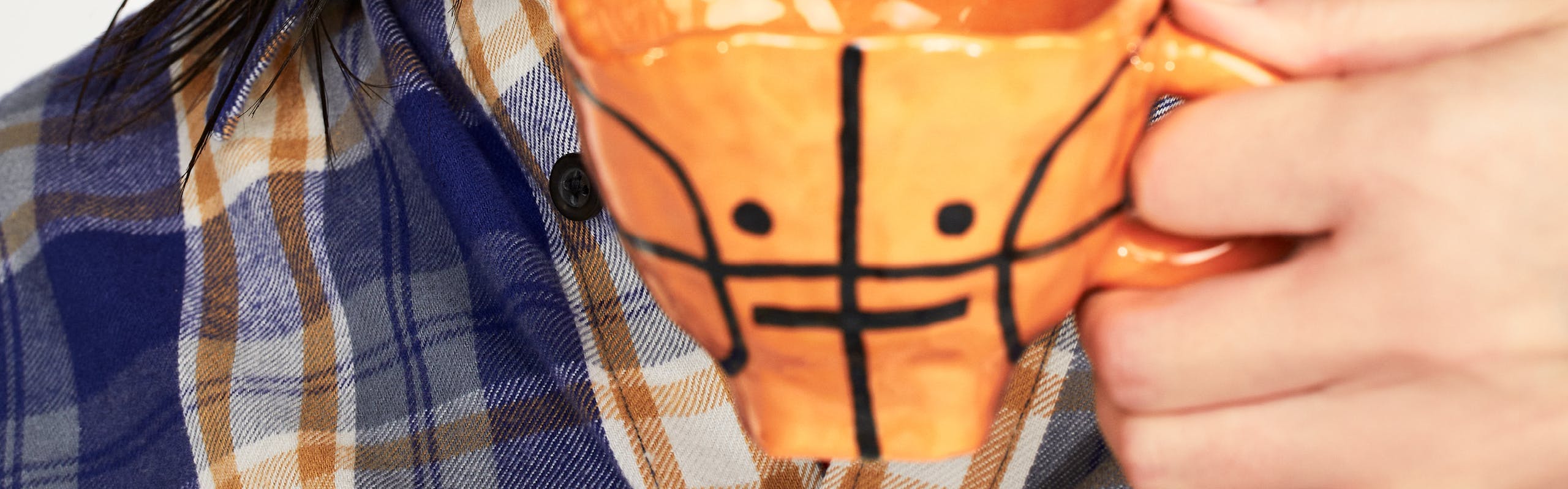 Modella orientale ssorseggia da una tazzina da tè con la forma di una palla da basket