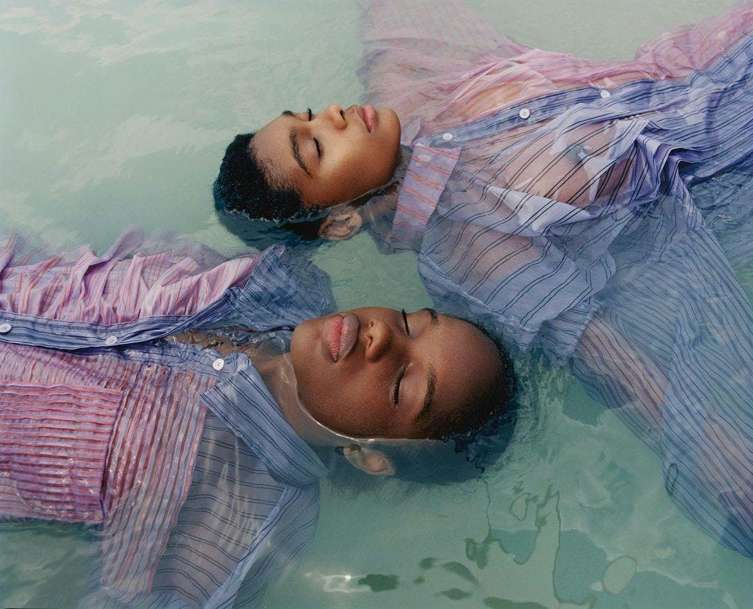 Due ragazzi di colore galleggiano in acqua vestiti 