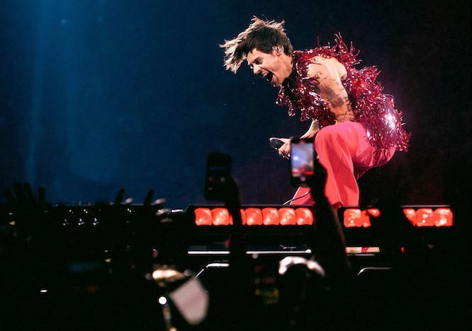 In foto Harry Styles che apre il tour con un gilet in pailettes di Gucci e torso nudo