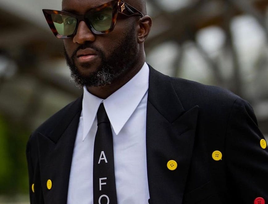 tie accessories suit coat overcoat clothing person sunglasses face necktie