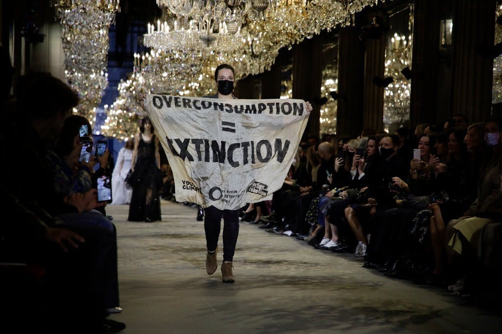 L'irruzione durante la sfilata di Louis Vuitton Primavera Estate 2022-23 al Louvre di una manifestante contro il consumismo.