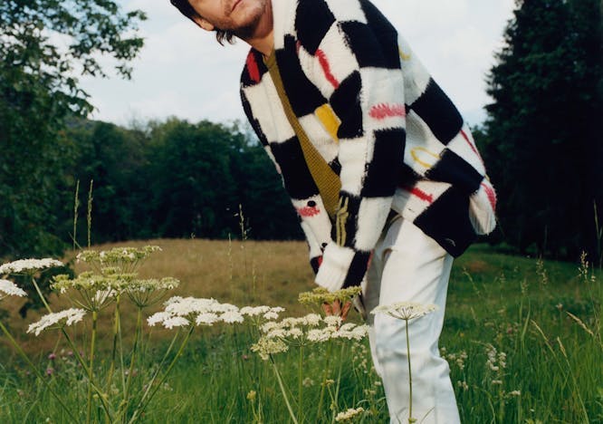 field grassland outdoors knitwear sweater grass person pants smile portrait